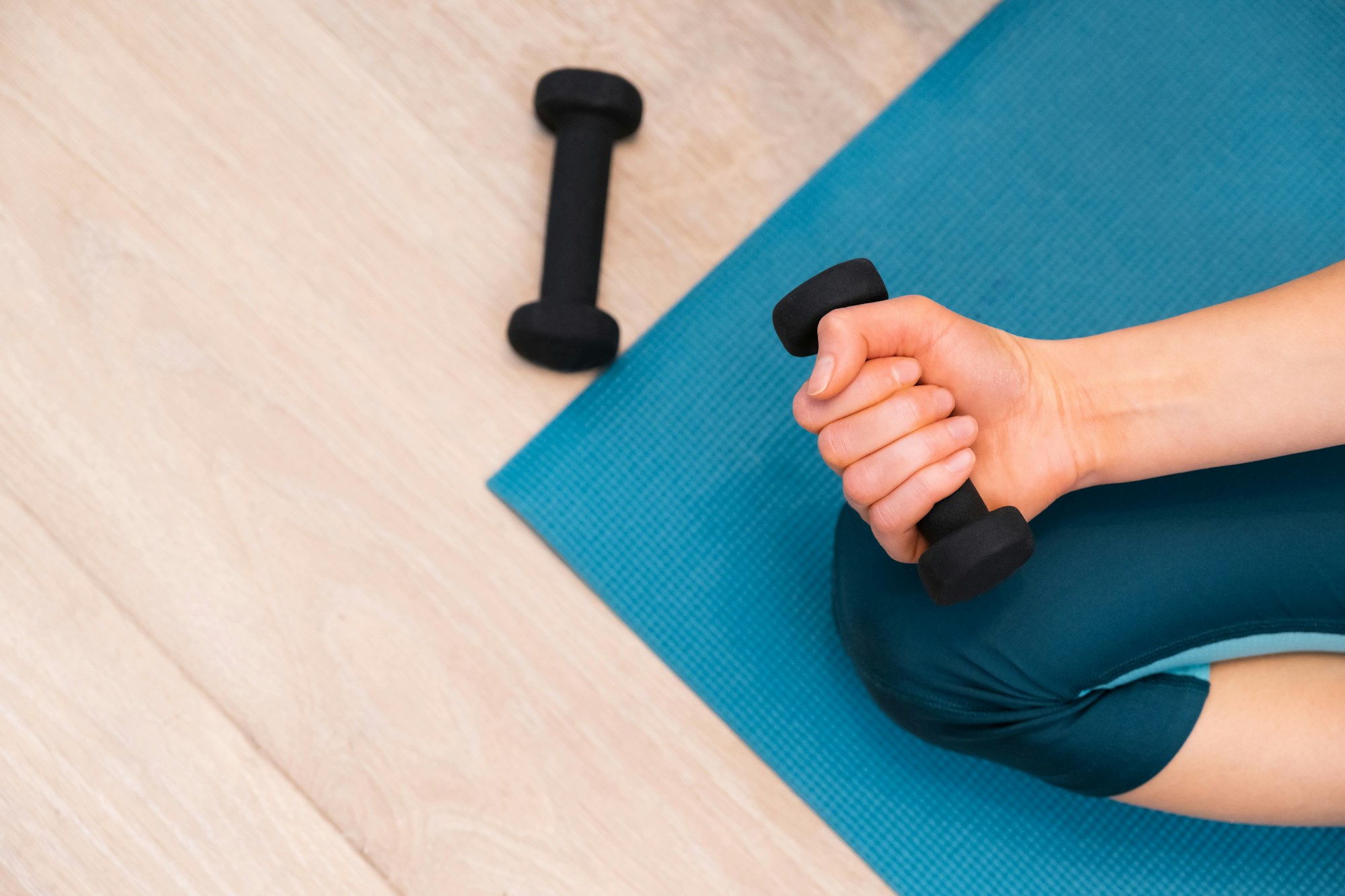 Slender young woman is doing gymnastics on a gymnastic mat at home.